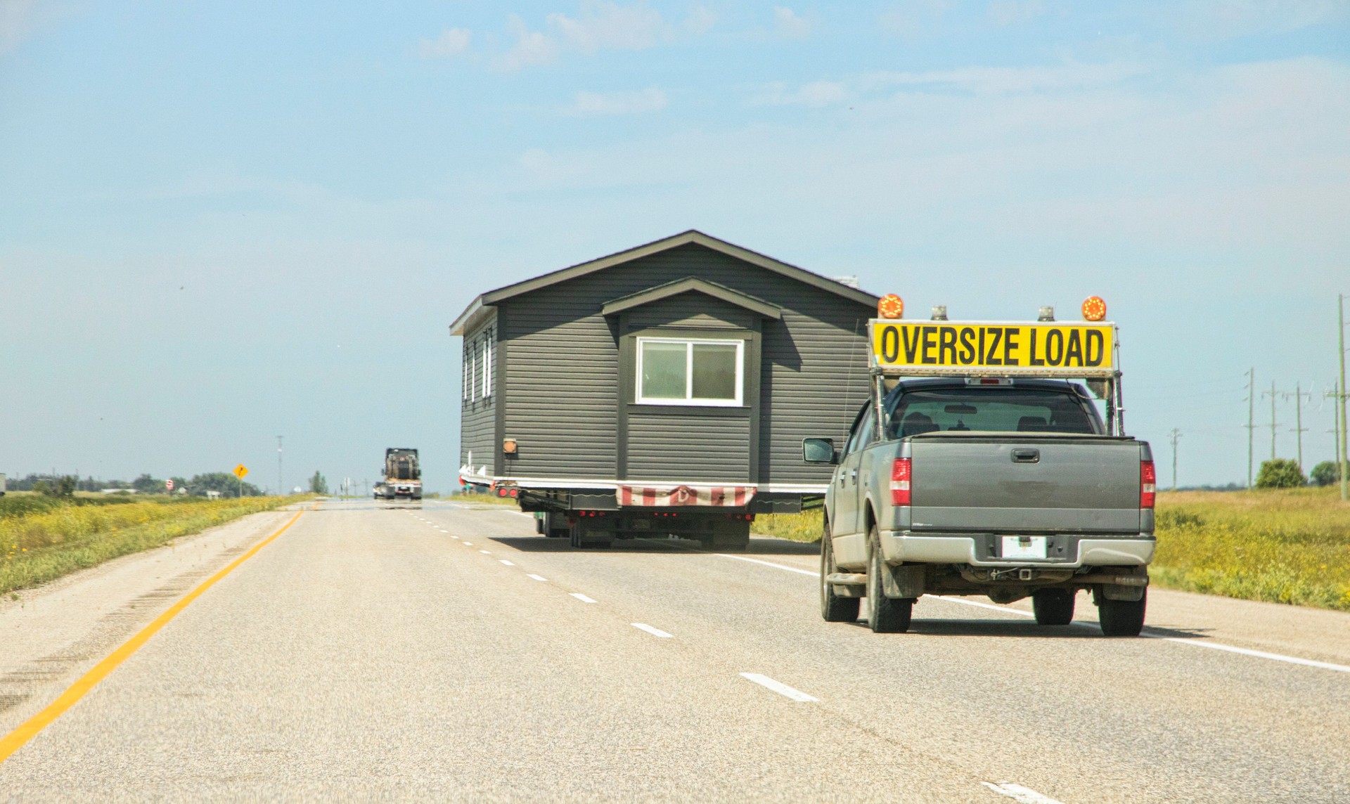 Transporting a House Trailer Down a Highway on Flatbed Truck